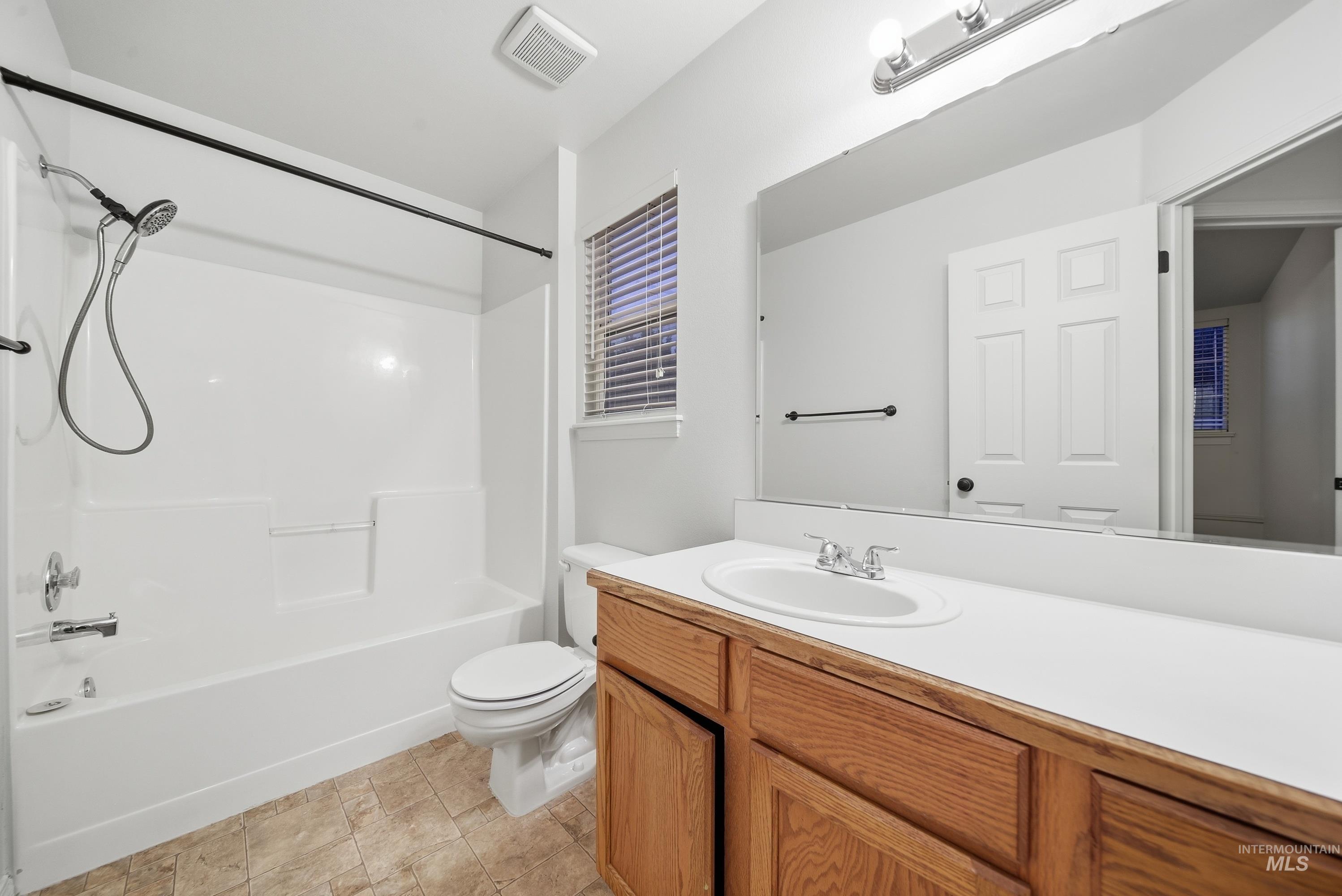 919 East Hawk Street Meridian, ID 83646 - Photo 26 of 31 White countertop vanity with wood-finish cabinetry, integrated sink, and chrome faucet
