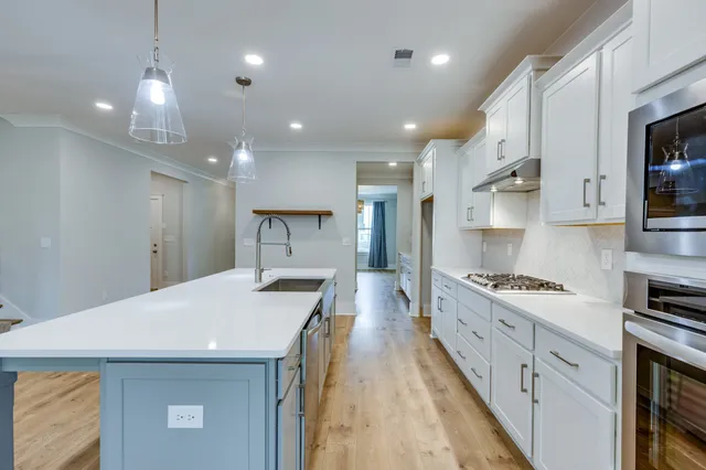 an empty room with wooden floor fireplace and windows