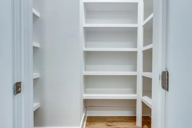a view of walk in closet with empty racks