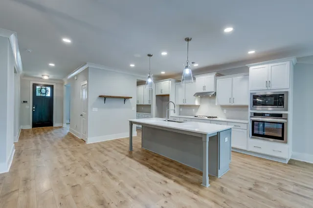 a kitchen with stainless steel appliances granite countertop a stove a sink and a refrigerator