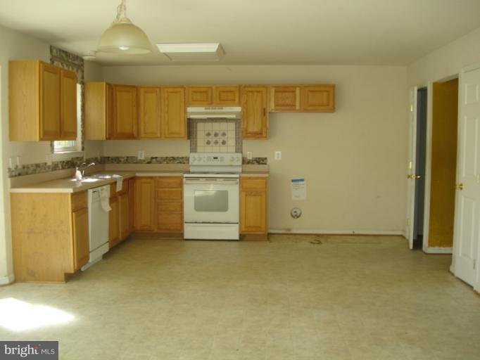 570 Balsom Road Lusby, MD 20657 - Photo 7 of 16 a kitchen with stainless steel appliances granite countertop a stove a sink and a refrigerator