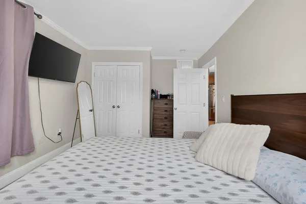 a bedroom with a bed and a flat screen tv