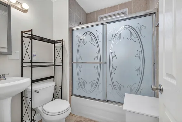 a bathroom with a shower a toilet and a sink