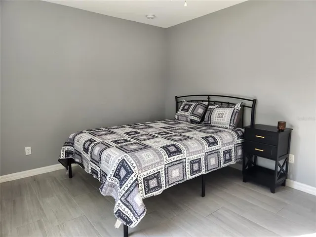 a bed sitting in a bedroom next to a lamp