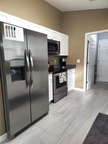 a kitchen with stainless steel appliances granite countertop a refrigerator and a stove