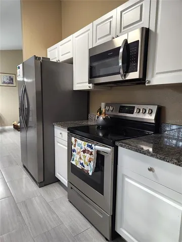a kitchen with stainless steel appliances granite countertop a stove a microwave and a refrigerator