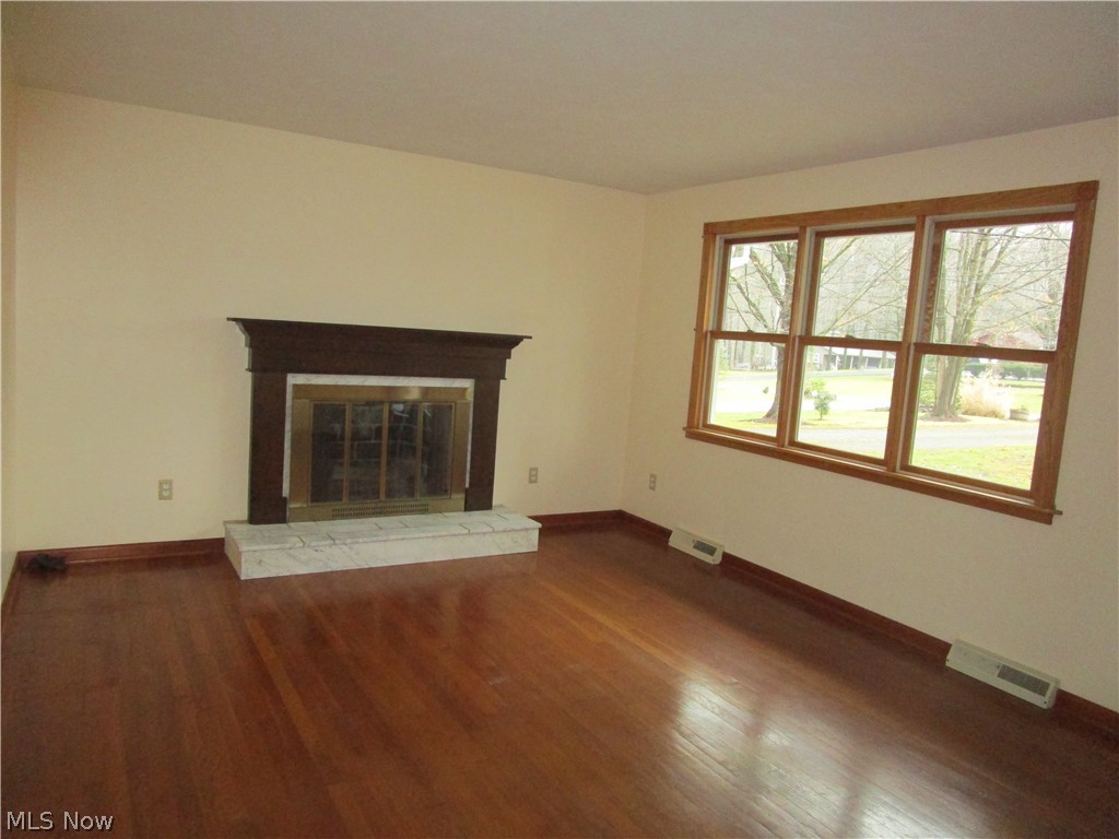 16704 Shedd Road Middlefield, OH 44062 - Photo 10 of 30 The large living room has lots of light, original wood floors and a wood burning fireplace.