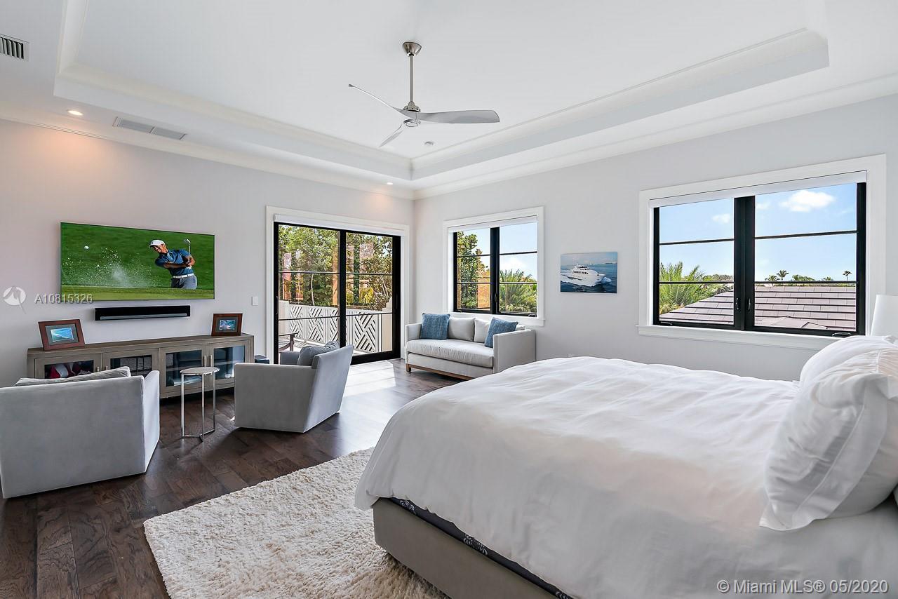 220 Commodore Drive Jupiter, FL 33477 - Photo 24 of 55 a bedroom with a large bed and a flat tv screen