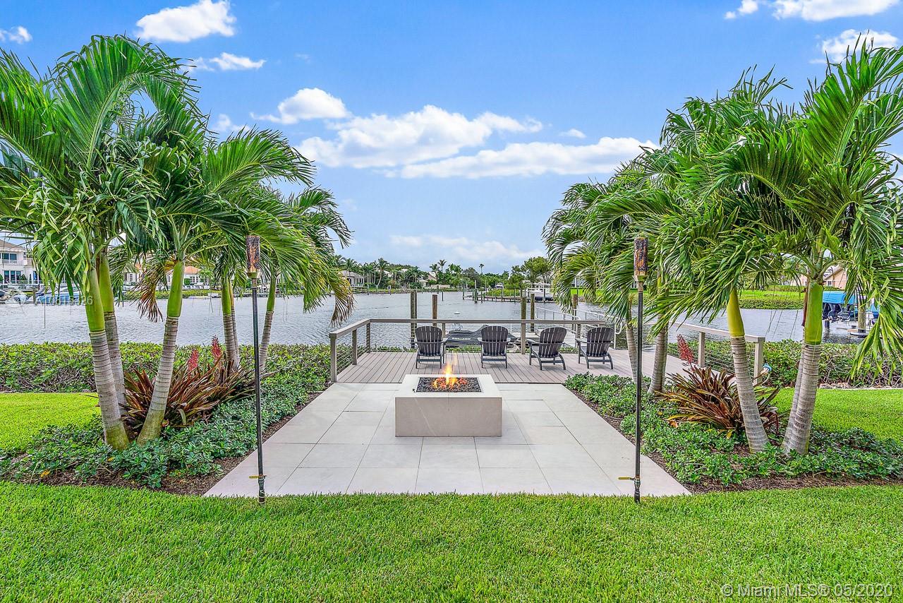 220 Commodore Drive Jupiter, FL 33477 - Photo 3 of 55 a view of a backyard with couches under an umbrella