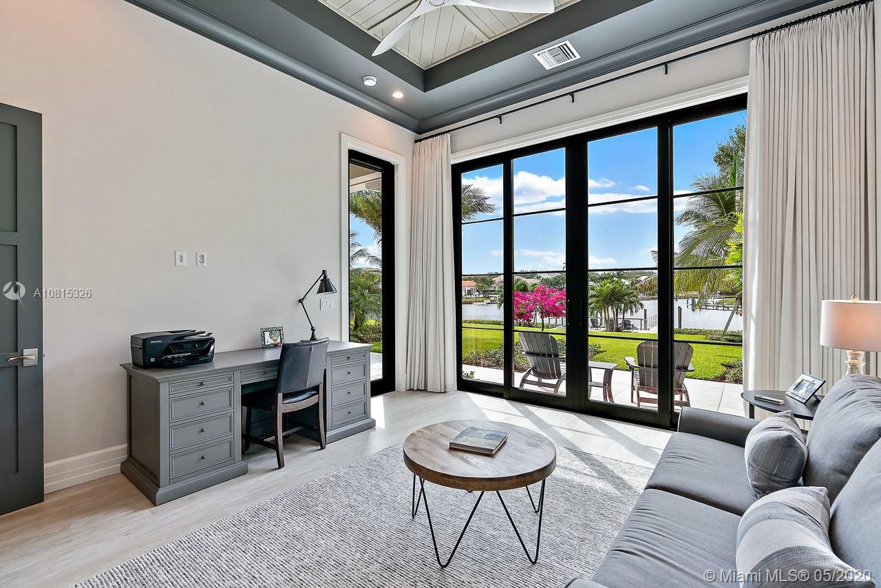220 Commodore Drive Jupiter, FL 33477 - Photo 38 of 55 a living room with furniture a floor to ceiling window and a table