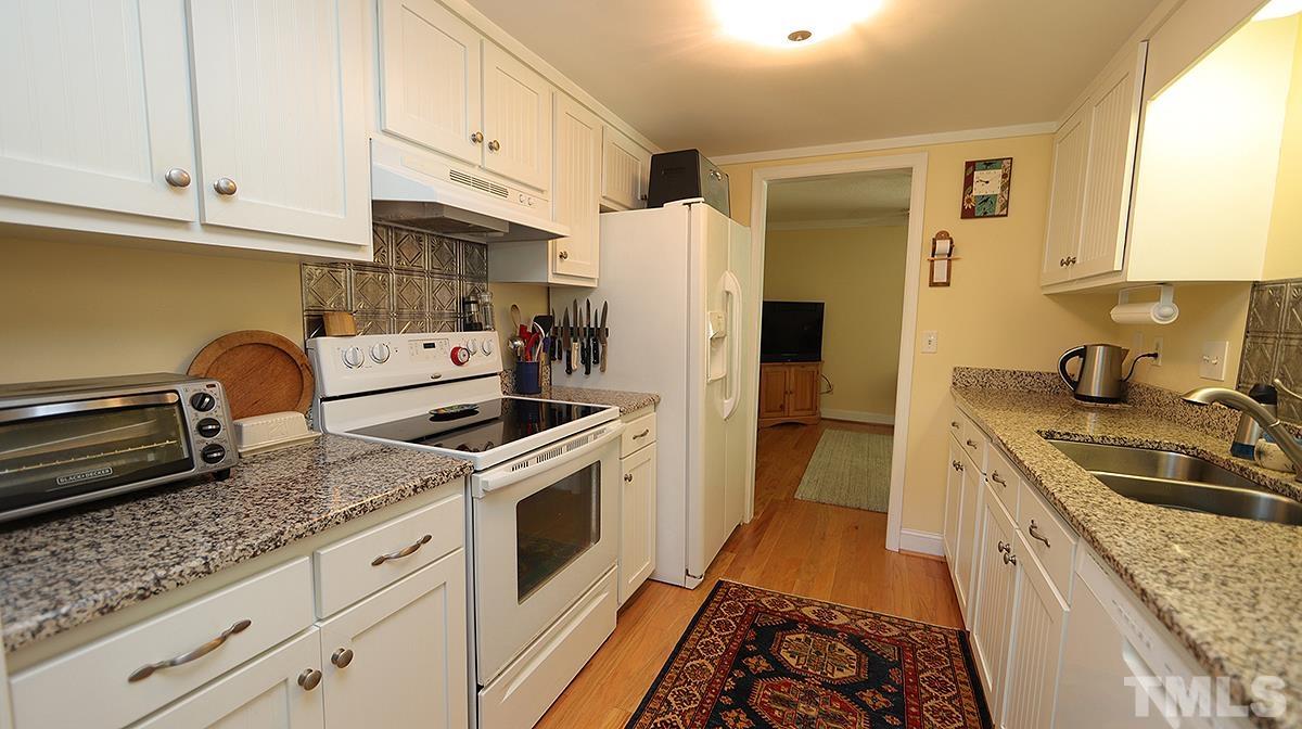 3137 Morningside Drive Raleigh, NC 27607 - Photo 4 of 15 a kitchen with granite countertop a sink stove and refrigerator