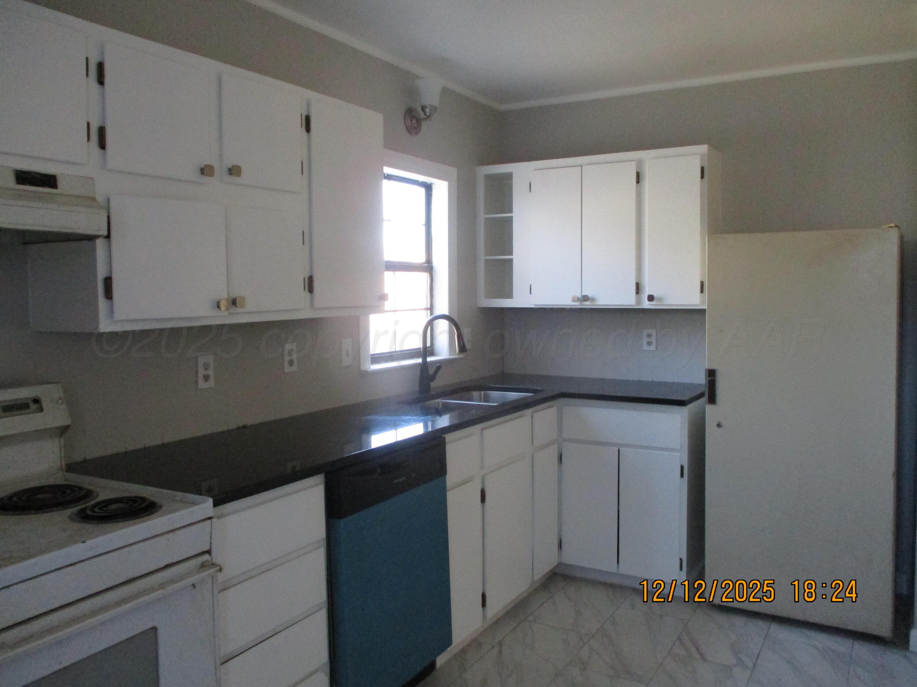 3108 South Tyler Street Amarillo, TX 79109 - Photo 4 of 11 a kitchen with granite countertop white cabinets and a stove