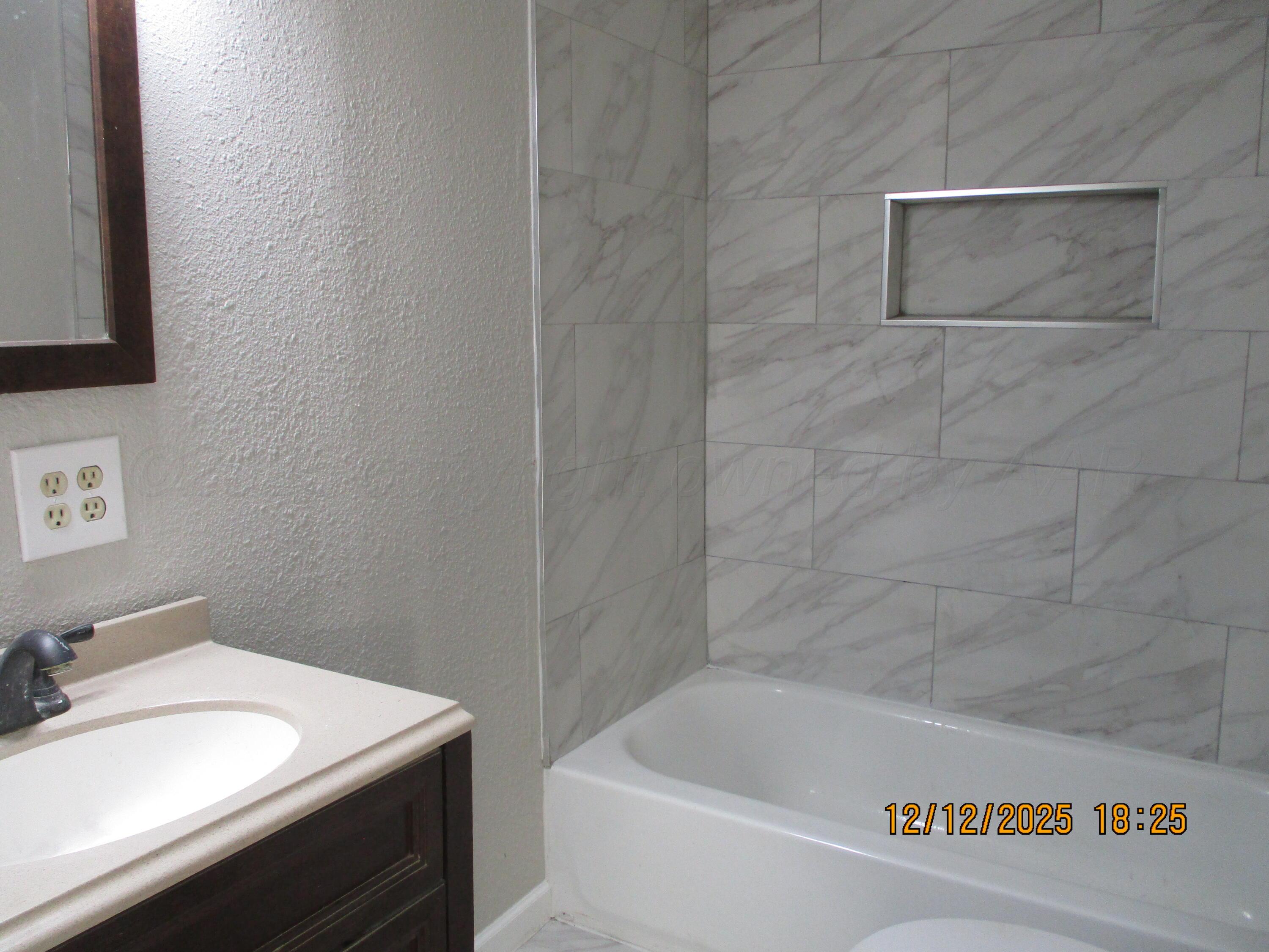 3108 South Tyler Street Amarillo, TX 79109 - Photo 6 of 11 a bath tub sitting next to a white sink