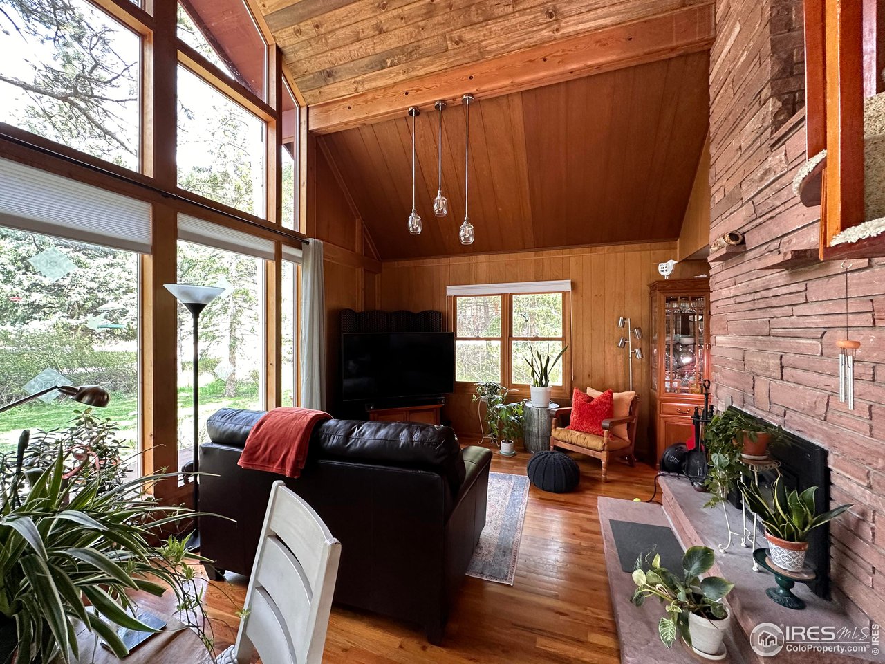 702 Riverside Drive Lyons, CO 80540 - Photo 2 of 19 a living room with fireplace furniture and a floor to ceiling window