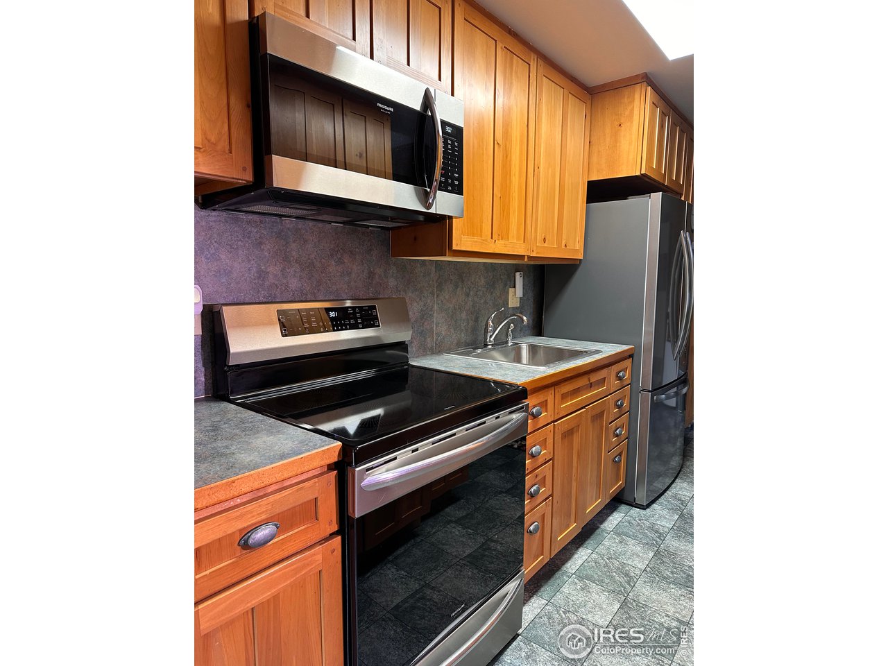 702 Riverside Drive Lyons, CO 80540 - Photo 6 of 19 a kitchen with stainless steel appliances granite countertop a stove and a microwave