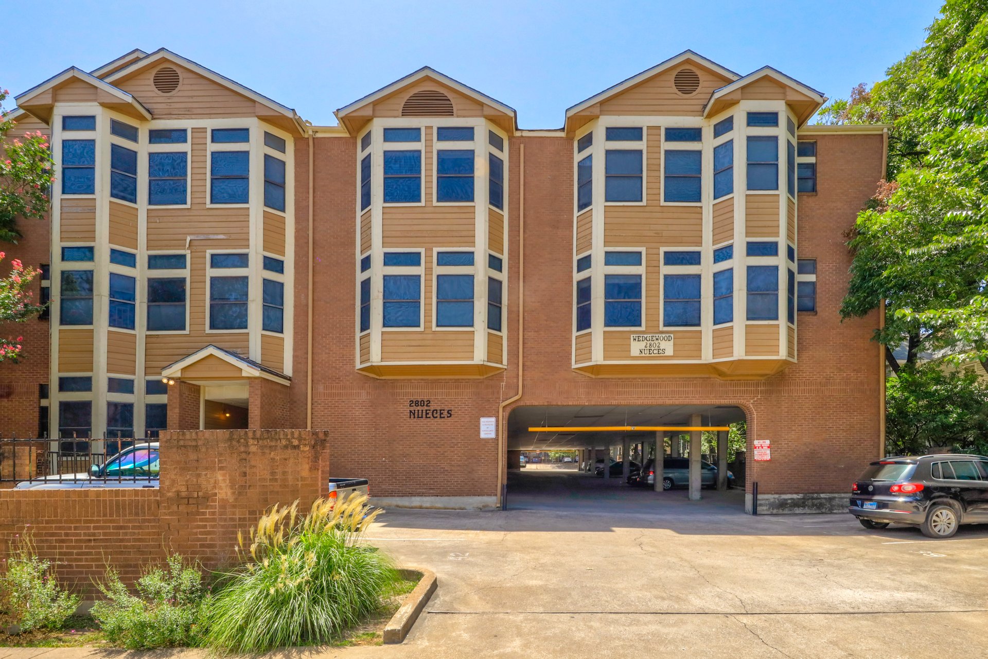 2802 Nueces Street, Unit 306 Austin, TX 78705 - Photo 1 of 20 Multi-story brick building with covered ground-level parking