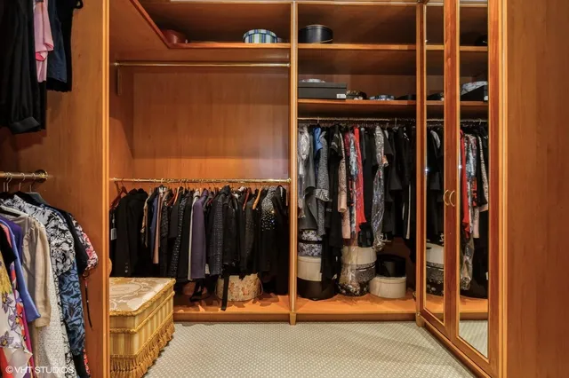 a view of walk in closet with clothes