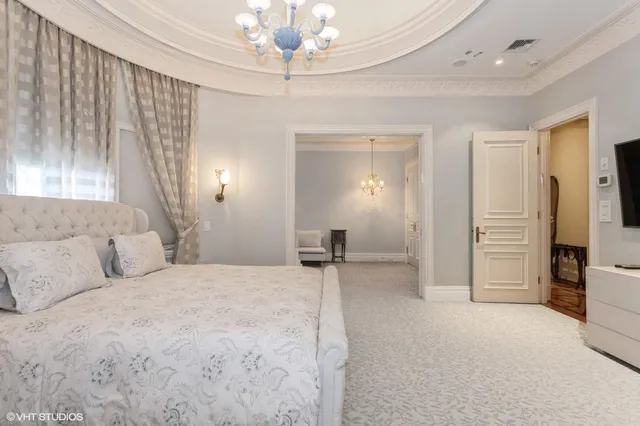 a spacious bedroom with a bed and a chandelier