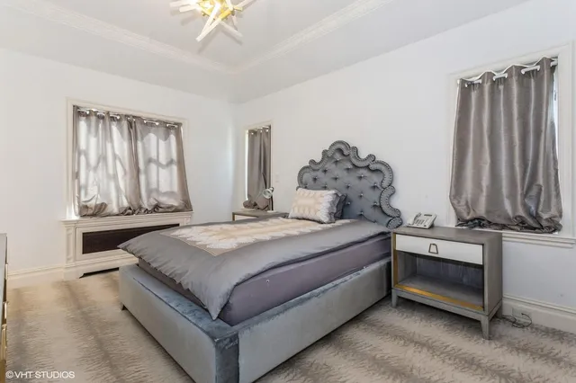 a bedroom with a bed and a chandelier