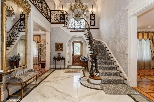 a view of a hallway with wooden floor windows and a chandelier