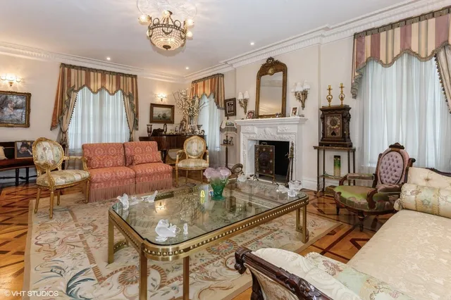 a living room with furniture a fireplace and a chandelier