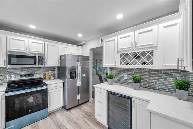 a kitchen with stainless steel appliances a refrigerator sink and microwave