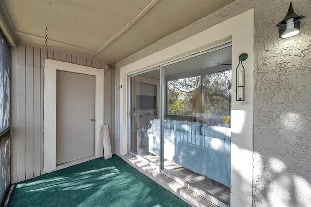 a view of a hallway to room with wooden floor and windows