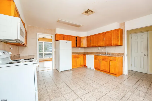 a view of a kitchen with a sink and a refrigerator