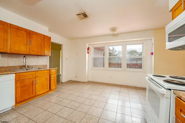 a view of kitchen with stainless steel appliances granite countertop a stove a sink and a microwave