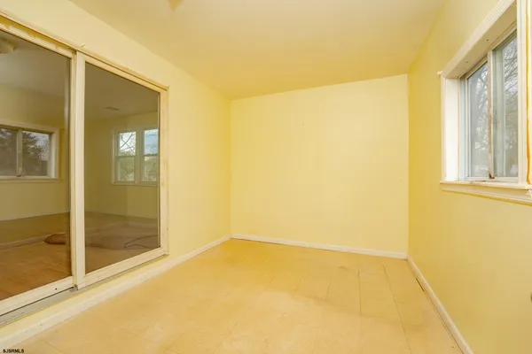 a view of a big room with wooden floor and windows