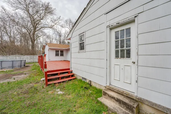 a backyard of a house with a barbeque and wooden fence