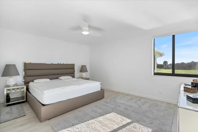 a bedroom with a bed and a large window