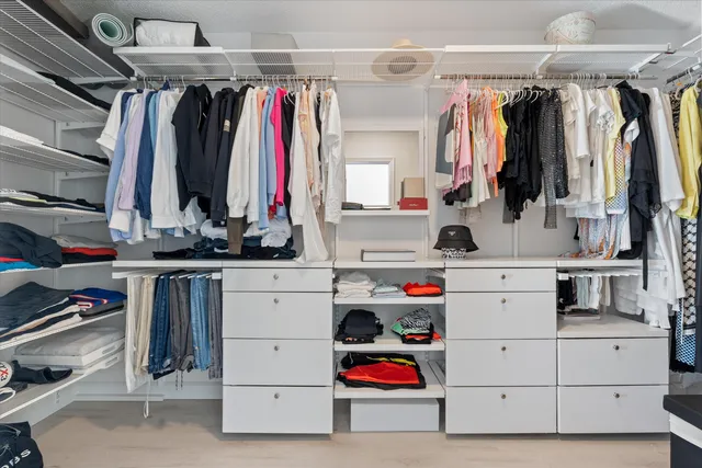 a view of walk in closet with clothes and shoes