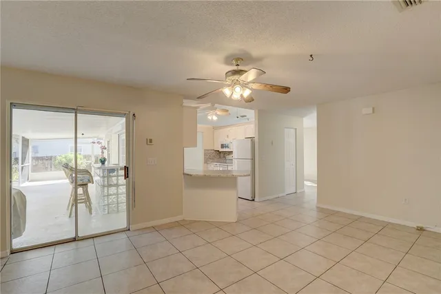 a view of a livingroom with a chandelier fan and windows
