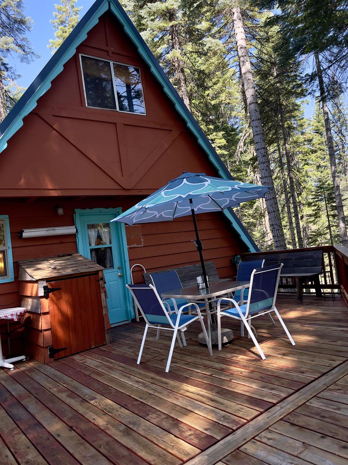 1743 Fiddleneck Road Strawberry Valley, CA 95981 - Photo 13 of 20 a view of a roof deck with table and chairs under an umbrella with wooden floor