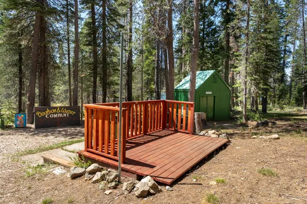a view of a wooden deck with trees in the background