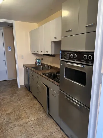 a kitchen with stainless steel appliances granite countertop a sink stove and cabinets