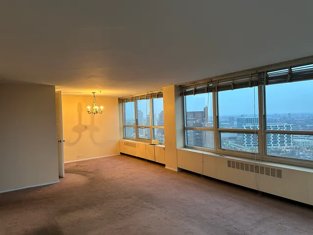 an empty room with large windows and city view