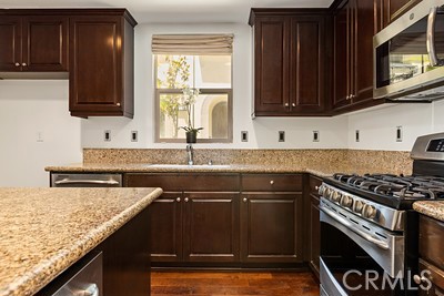 20332 Paseo Meriana Porter Ranch, CA 91326 - Photo 4 of 19 a kitchen with granite countertop a sink a stove and cabinets