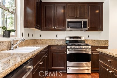20332 Paseo Meriana Porter Ranch, CA 91326 - Photo 5 of 19 a kitchen with granite countertop a stove and a microwave