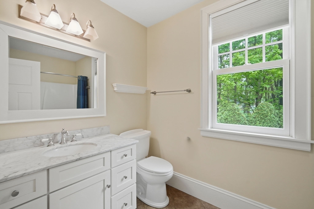 151 Amity Street, Unit 2 Amherst, MA 01002 - Photo 11 of 42 a bathroom with a granite countertop toilet a sink a window and mirror