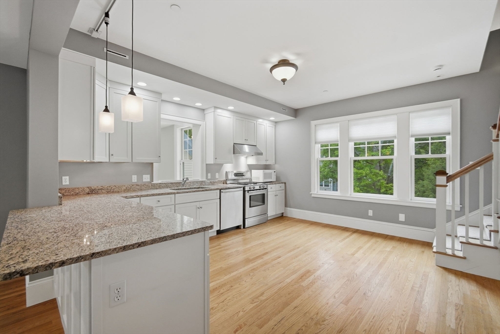 151 Amity Street, Unit 2 Amherst, MA 01002 - Photo 17 of 42 a large kitchen with stainless steel appliances granite countertop a stove a sink and a large window