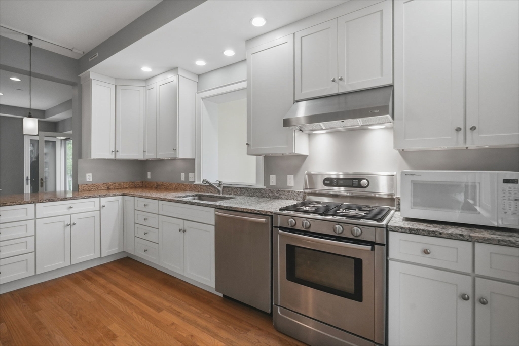 151 Amity Street, Unit 2 Amherst, MA 01002 - Photo 19 of 42 a kitchen with granite countertop cabinets stainless steel appliances and a sink