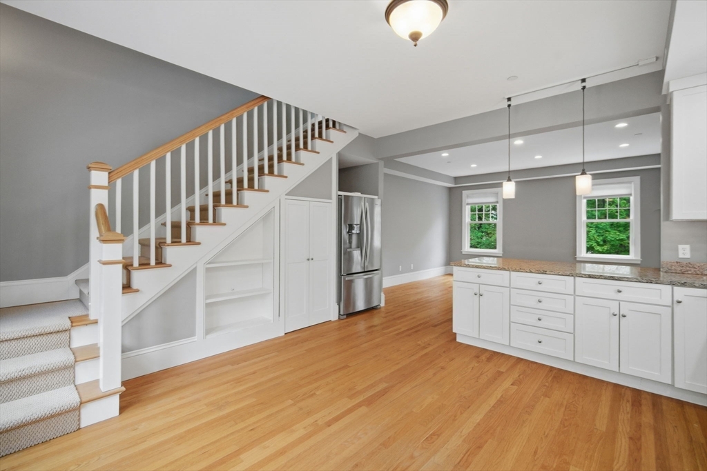 151 Amity Street, Unit 2 Amherst, MA 01002 - Photo 20 of 42 a large white kitchen with wooden floor and entryway