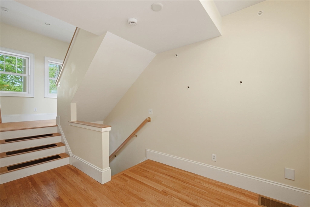 151 Amity Street, Unit 2 Amherst, MA 01002 - Photo 6 of 42 a view of an empty room with wooden floor and stairs