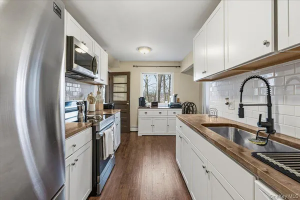 a large kitchen with stainless steel appliances granite countertop a sink a stove and cabinets
