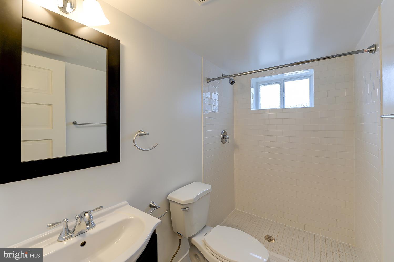 1334 Queen Street Northeast Washington, DC 20002 - Photo 16 of 29 a bathroom with a toilet sink a mirror and shower