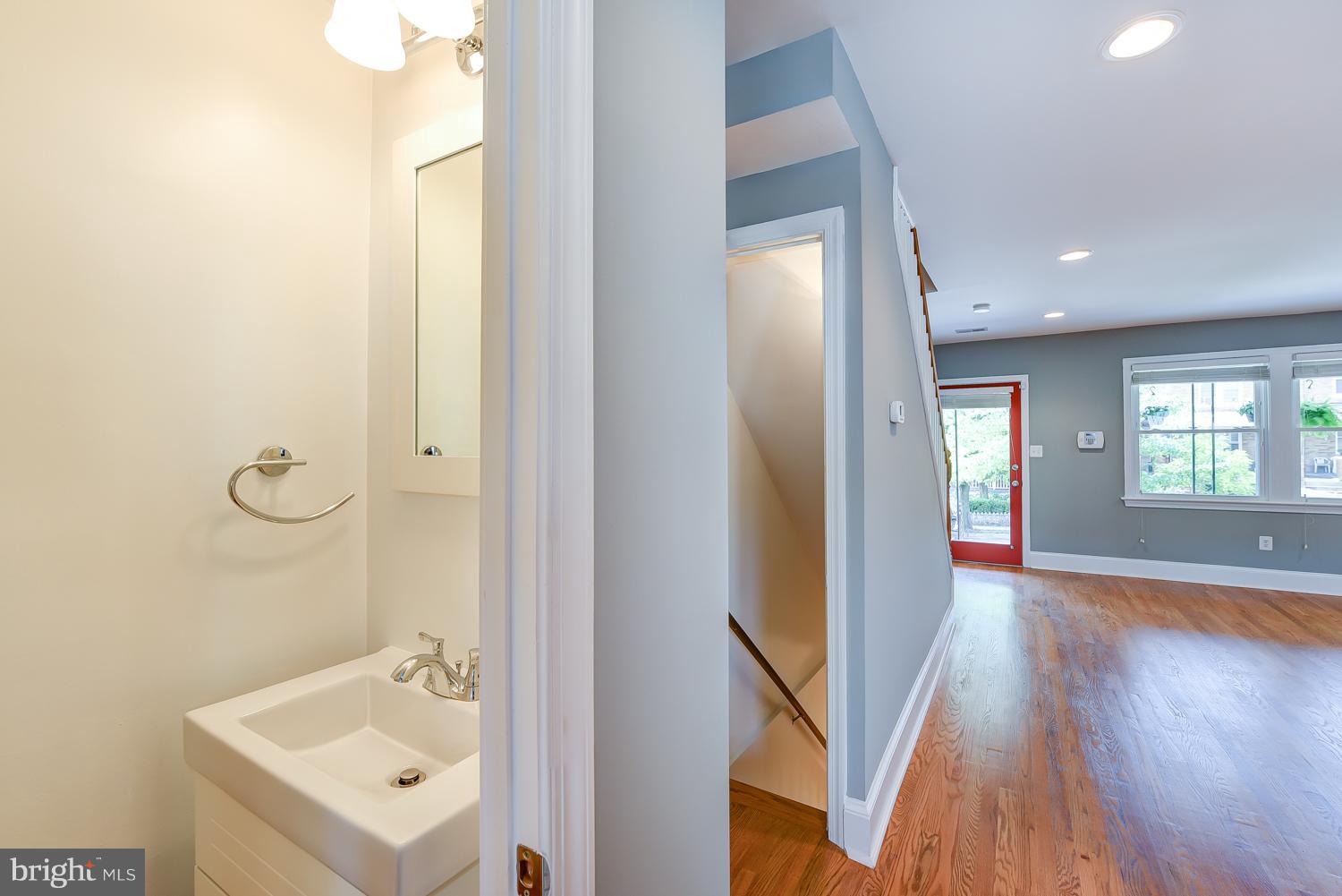 1334 Queen Street Northeast Washington, DC 20002 - Photo 7 of 29 a view of a hallway with wooden floor and a bathroom