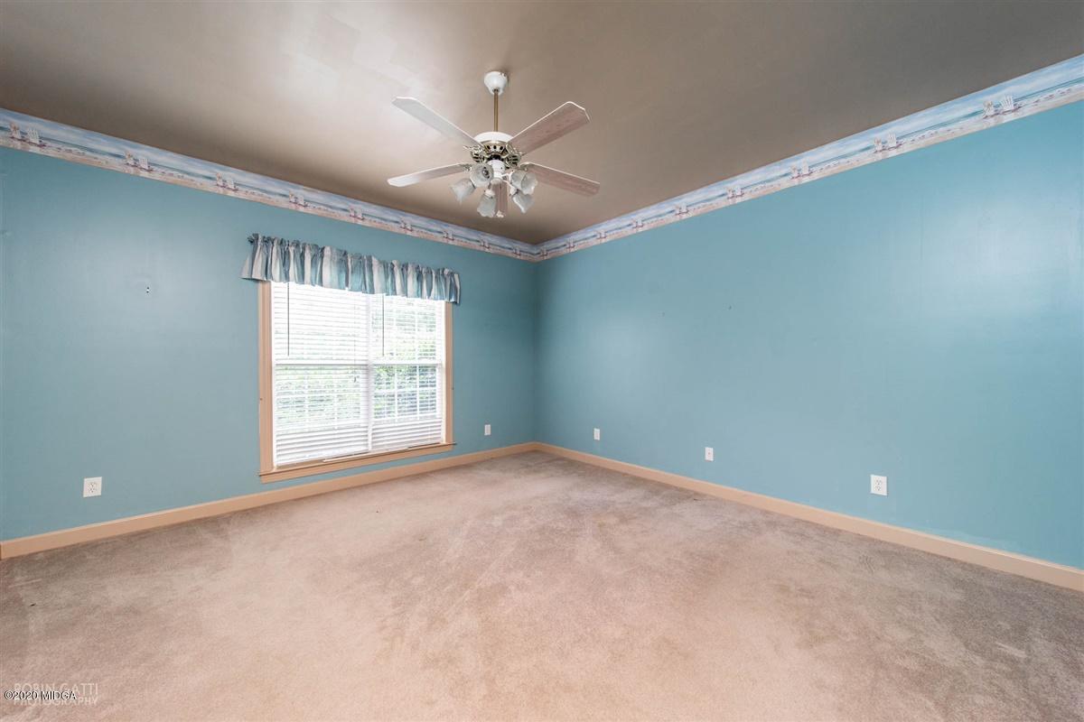 4271 Upper River Road Gray, GA 31032 - Photo 6 of 40 an empty room with chandelier fan and windows