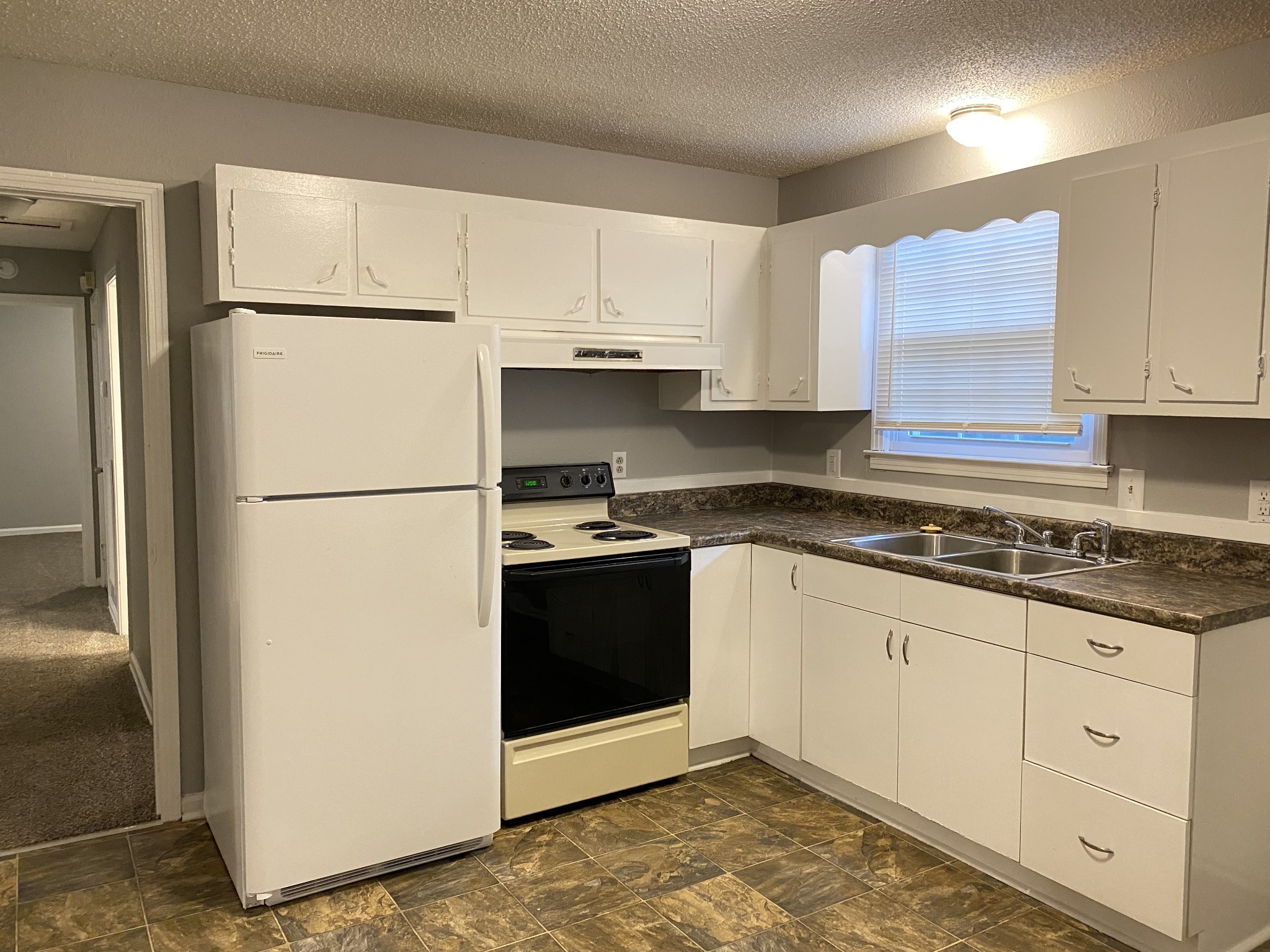 222 North 11th Street Clarksville, TN 37040 - Photo 3 of 14 a kitchen with granite countertop white cabinets and refrigerator